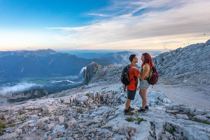 Das Paar genießt romantisch auf dem Kanin-Berg bei Sonnenuntergang mit Blick auf das Tal