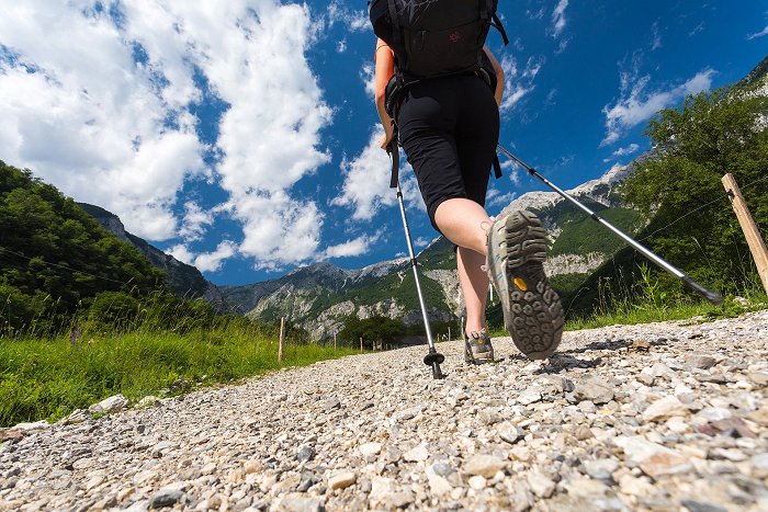 In Wanderschuhen und Wanderstöcken macht sich der Wanderer auf den Weg.