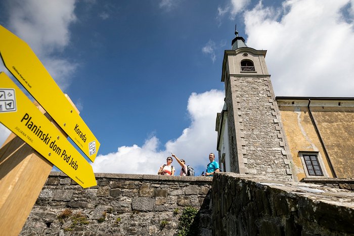 Wanderer genießen die Aussicht vor der Kirche