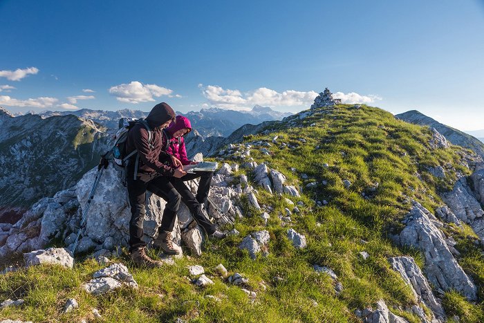 Gli escursionisti in cima alla montagna studiano la mappa