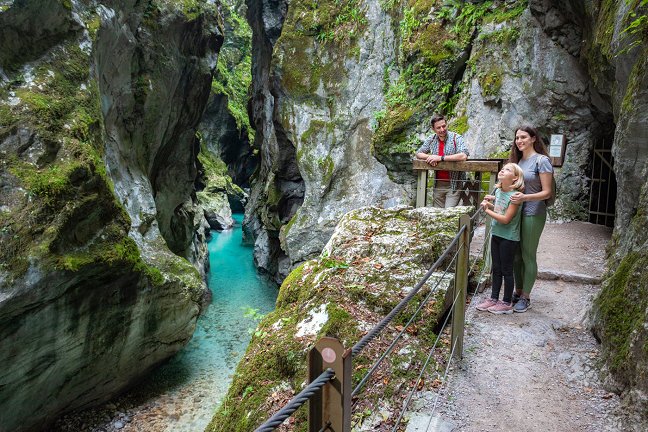 La famiglia gode della vista sulla stretta gola di Tolminka e sul fiume Tolminka verde-azzurro.