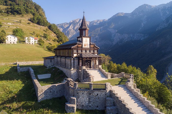 Razgled na zunanjost spominske cerkve iz lesa in kamna. 